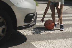 kid grabbing basketball in crosswalk